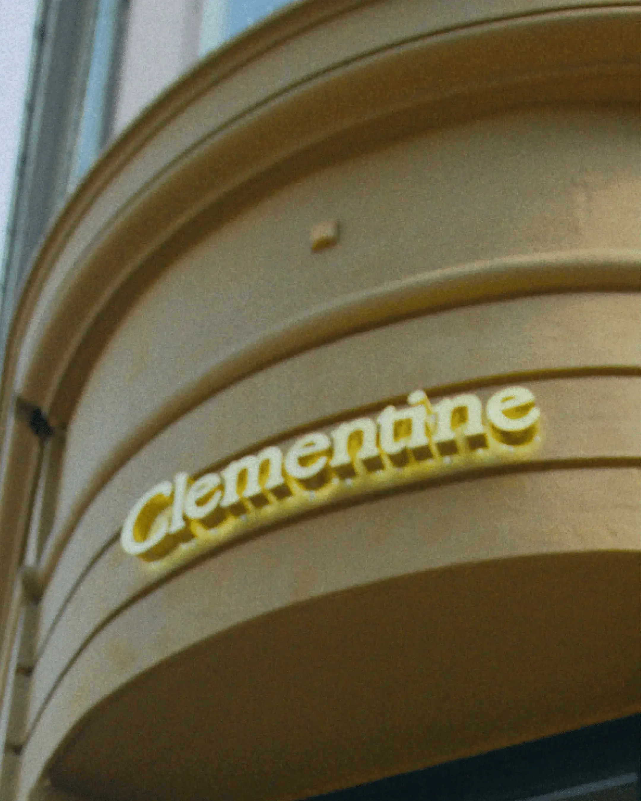 Yellow storefront sign with the word "Clementine" in curved, white letters on a rounded facade.